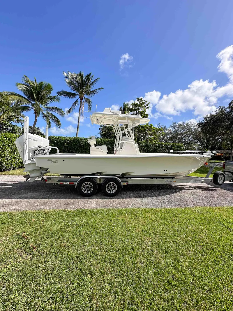 Slide: The Image of 2022 SeaVee 270Z boat on trailer, parked outdoors with palm trees and blue sky. - 9