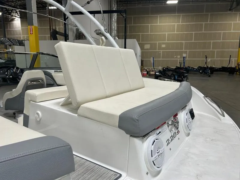 Slide: The Image of 2022 Cobalt 220S boat interior with white and gray seating in a warehouse. - 5