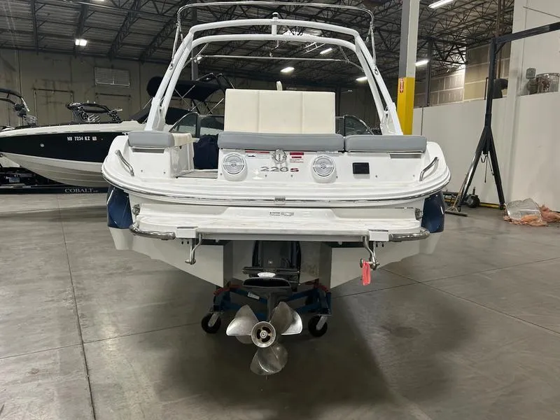 Slide: The Image of 2022 Cobalt 220S boat in a warehouse, rear view showing propeller and swim platform. - 6