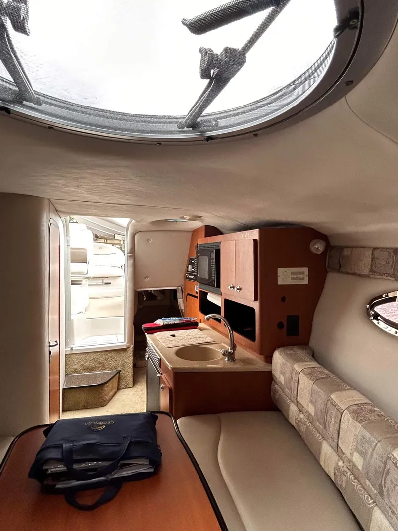 Slide: The Image of Interior of 2007 Crownline 270 CR boat, featuring kitchenette and seating area. - 13