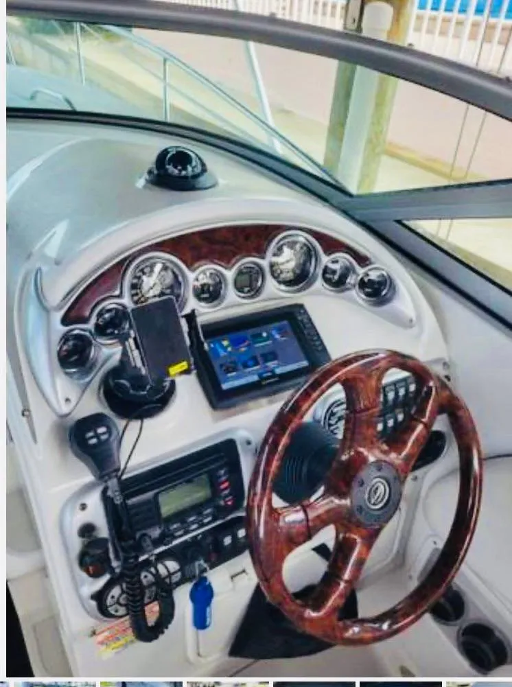 Slide: The Image of 2007 Crownline 270 CR boat dashboard with wood-trimmed steering wheel and modern navigation instruments. - 6