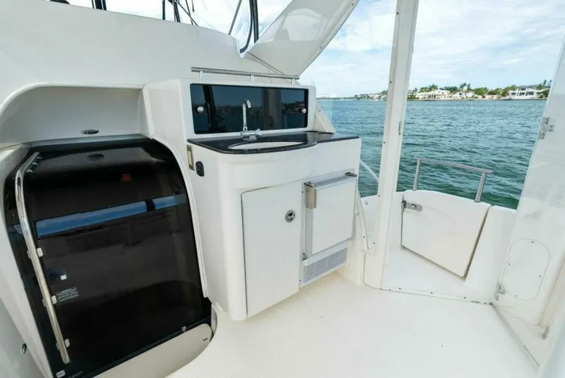 Slide: The Image of 2008 Meridian 459 Motoryacht deck with sink and storage, overlooking water. - 24