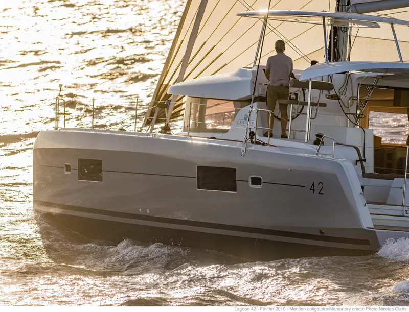 Slide: The Image of 2017 Lagoon 42 catamaran sailing on sunlit waters. - 1