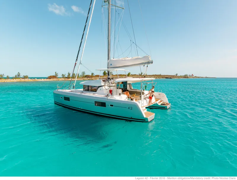 Slide: The Image of 2017 Lagoon 42 catamaran sailing in clear turquoise waters near a tropical island. - 11
