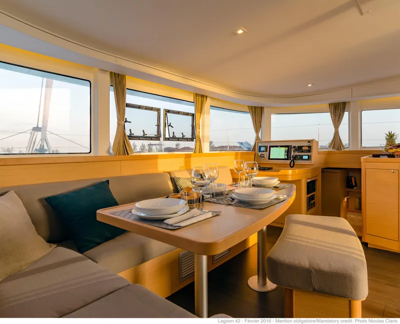 Slide: The Image of Interior of 2017 Lagoon 42 catamaran with elegant dining setup and panoramic windows. - 4