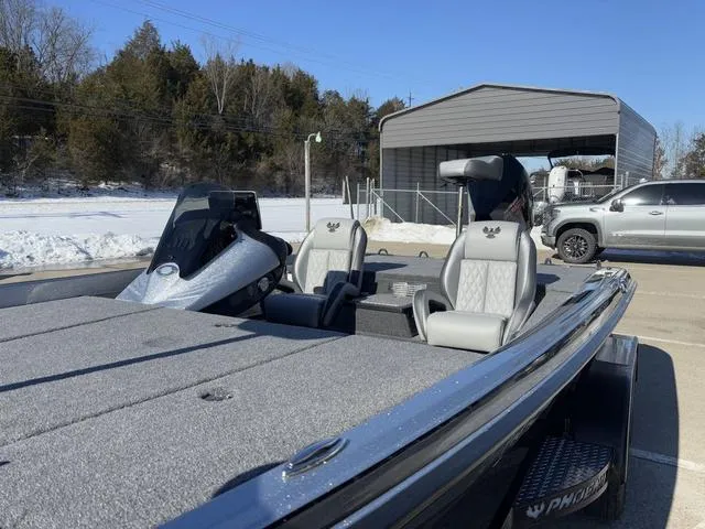 Slide: The Image of 2025 Phoenix 721 ZXL boat with dual seats, parked outdoors near a shed and snowy landscape. - 9