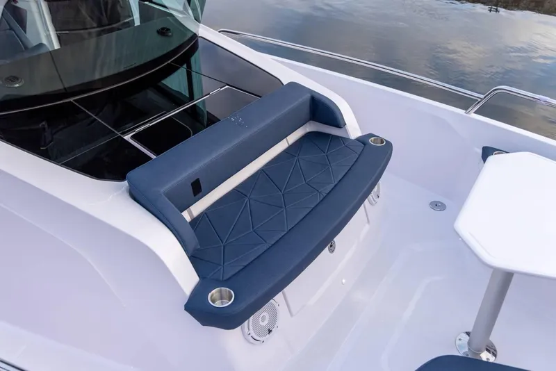 Slide: The Image of 2025 Axopar 29 XC Cross Cabin boat seating area with modern design and blue upholstery. - 8