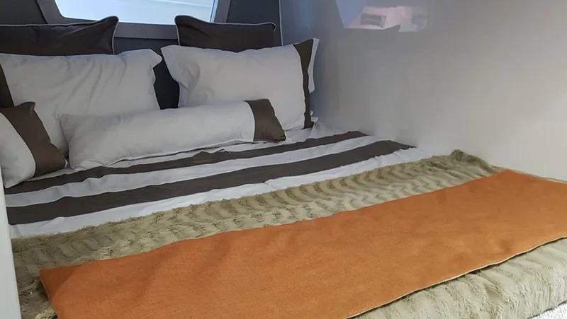 Slide: The Image of Interior cabin of 2025 Hanover 355 Outboard with cozy bedding and pillows. - 7