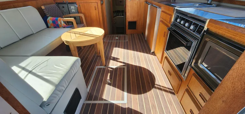 Slide: The Image of Interior of 1985 Bertram 33 Flybridge Cruiser with wood flooring and kitchen amenities. - 12