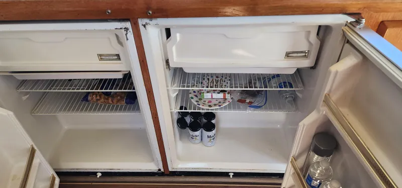 Slide: The Image of Open fridge on 1985 Bertram 33 Flybridge Cruiser with drinks and snacks inside. - 18