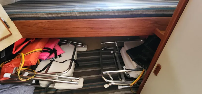 Slide: The Image of Interior storage of 1985 Bertram 33 Flybridge Cruiser with life jackets and folding chairs. - 21