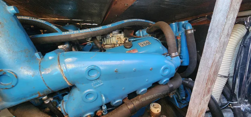 Slide: The Image of Engine compartment of a 1985 Bertram 33 Flybridge Cruiser with blue components and hoses. - 27