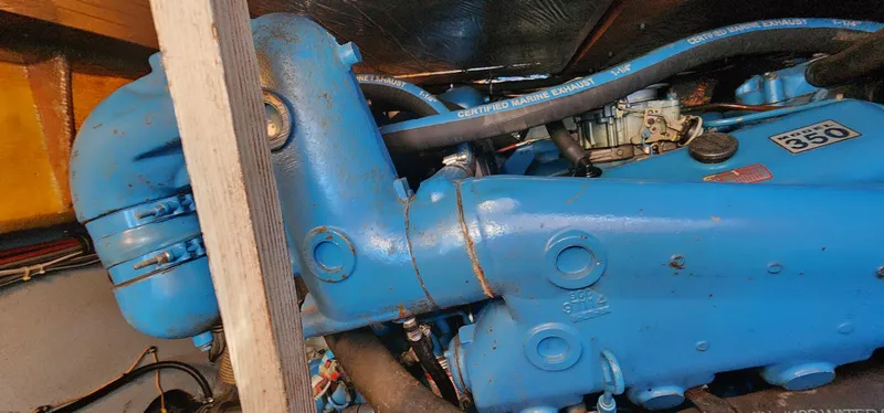 Slide: The Image of Engine compartment of a 1985 Bertram 33 Flybridge Cruiser, featuring a blue marine engine. - 28