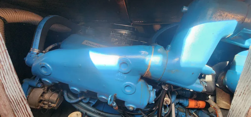 Slide: The Image of Engine of 1985 Bertram 33 Flybridge Cruiser, featuring blue components and visible hoses. - 30