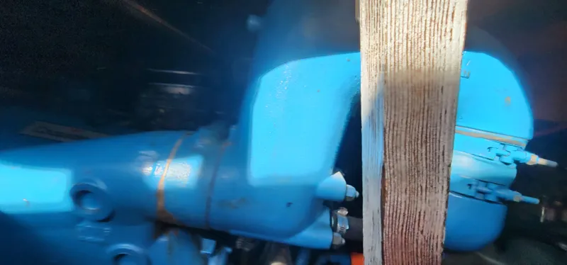 Slide: The Image of Engine compartment of a 1985 Bertram 33 Flybridge Cruiser, featuring a blue engine component. - 31