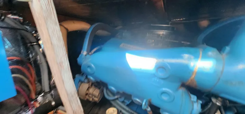 Slide: The Image of Engine compartment of a 1985 Bertram 33 Flybridge Cruiser with visible blue machinery. - 32