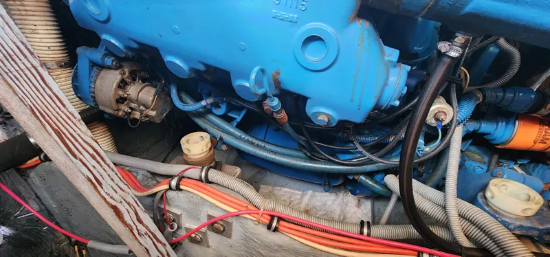 Slide: The Image of Engine compartment of a 1985 Bertram 33 Flybridge Cruiser with visible wiring and components. - 33