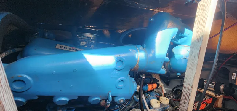 Slide: The Image of Engine compartment of a 1985 Bertram 33 Flybridge Cruiser with blue components. - 34