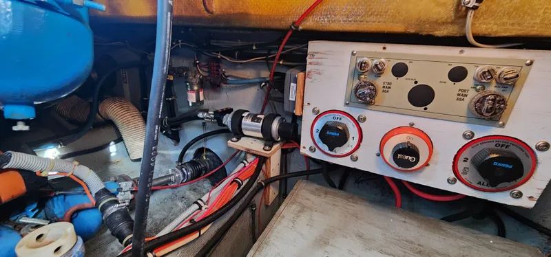 Slide: The Image of Engine room of a 1985 Bertram 33 Flybridge Cruiser, showcasing wiring and control panel. - 35