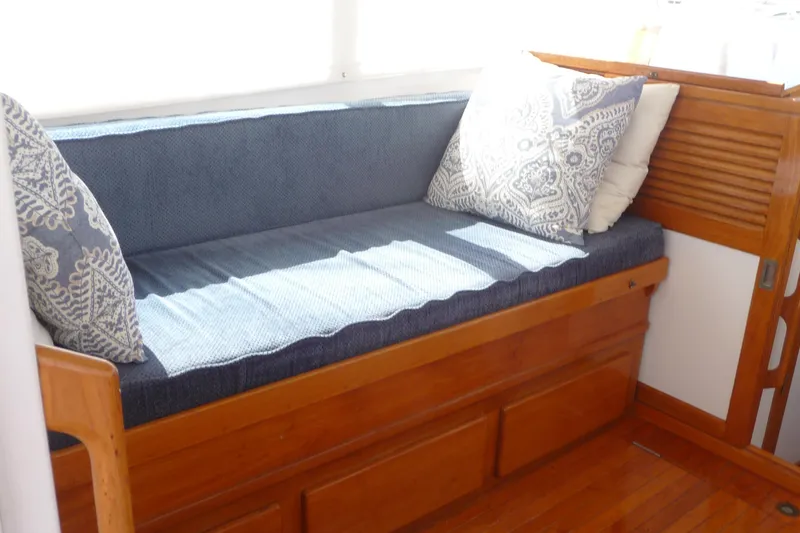 Slide: The Image of 1976 Roughwater 35 Pilothouse interior with blue cushioned seating and decorative pillows. - 11