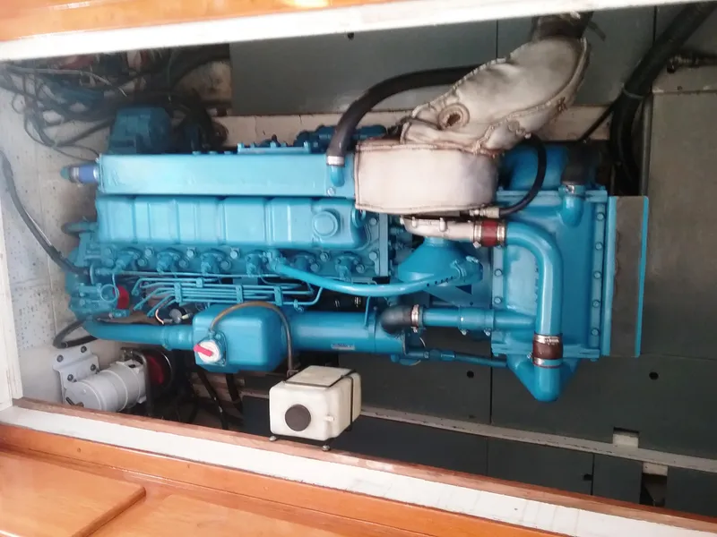 Slide: The Image of Engine compartment of a 1976 Roughwater 35 Pilothouse boat, featuring a blue marine engine. - 12