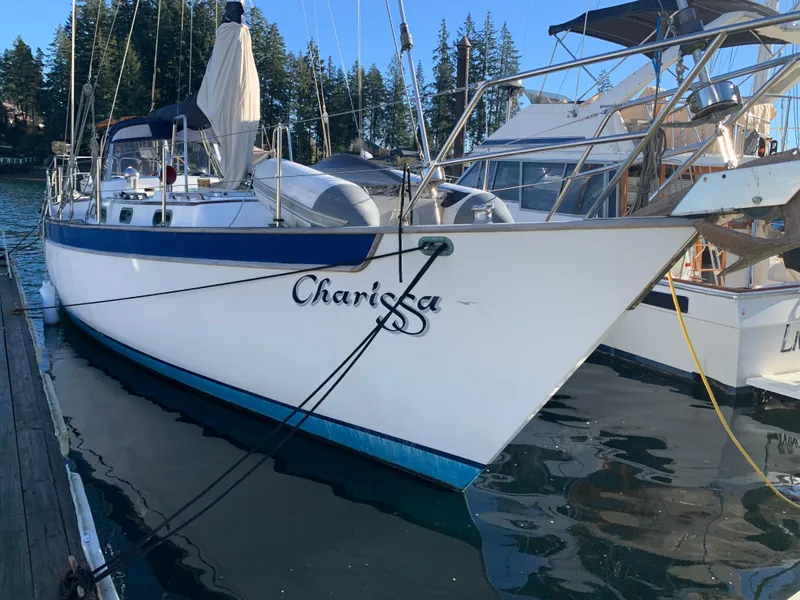 Slide: The Image of 1983 Liberty Center Cockpit sailboat docked in a marina, surrounded by water and trees. - 1
