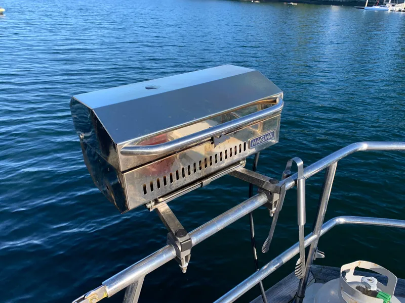 Slide: The Image of Stainless steel grill mounted on a 1983 Liberty Center Cockpit boat, overlooking calm water. - 12
