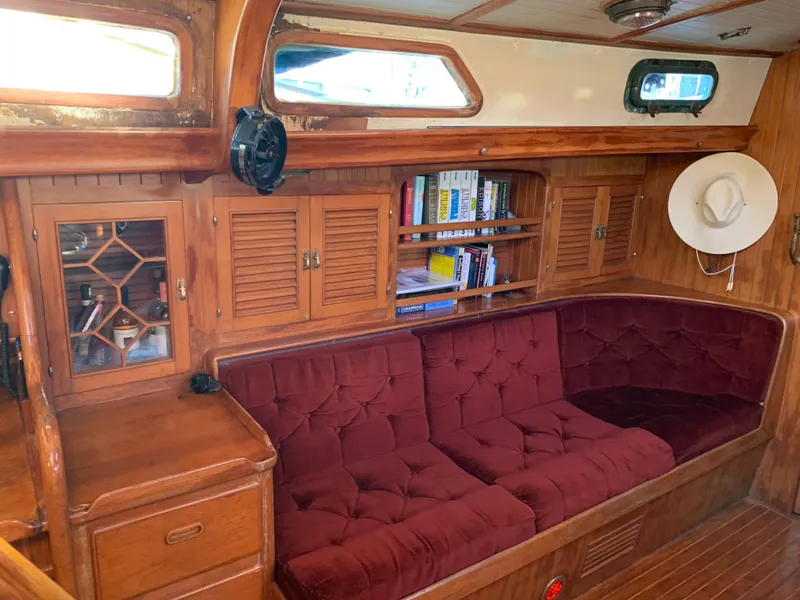 Slide: The Image of 1983 Liberty Center Cockpit interior with red cushioned seating, wooden cabinets, and bookshelves. - 16