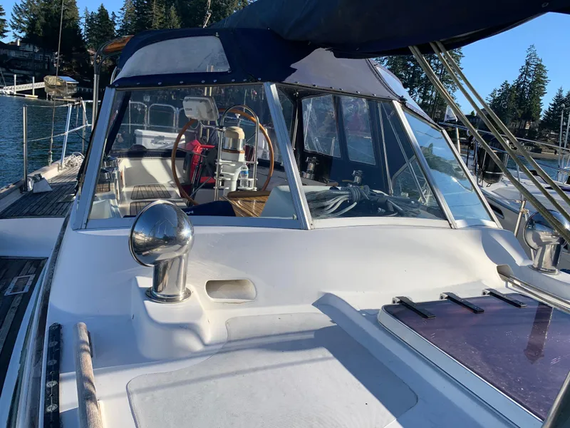 Slide: The Image of 1983 Liberty Center Cockpit sailboat with steering wheel, docked in a scenic marina. - 2
