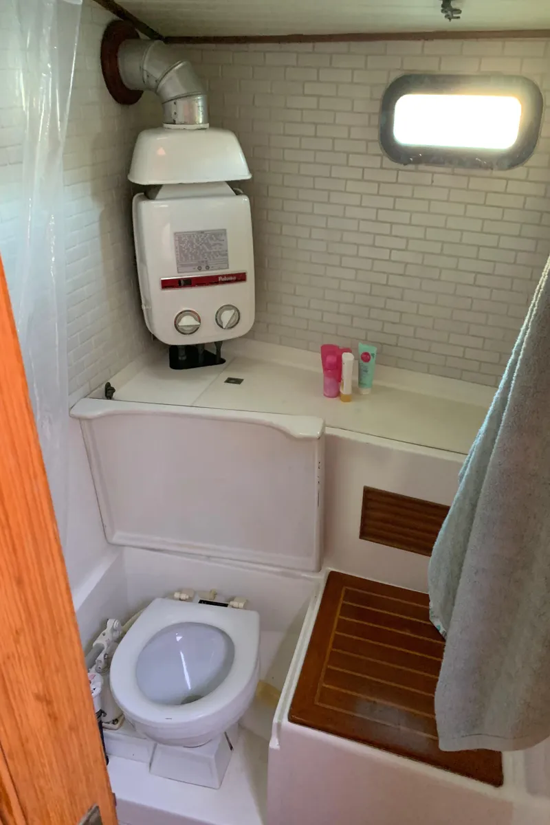 Slide: The Image of 1983 Liberty Center Cockpit bathroom with toilet, water heater, and toiletries. - 21