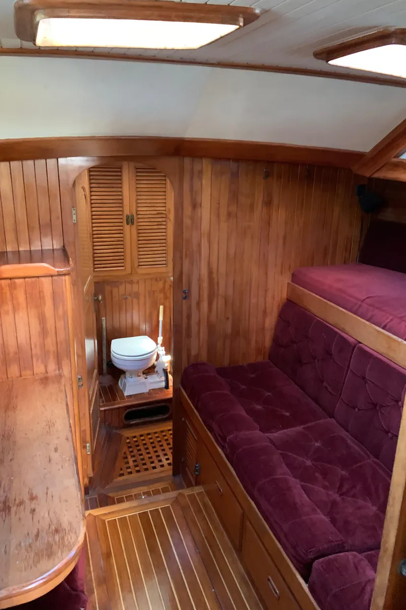 Slide: The Image of 1983 Liberty Center Cockpit interior with wood paneling, maroon seating, and compact bathroom. - 23