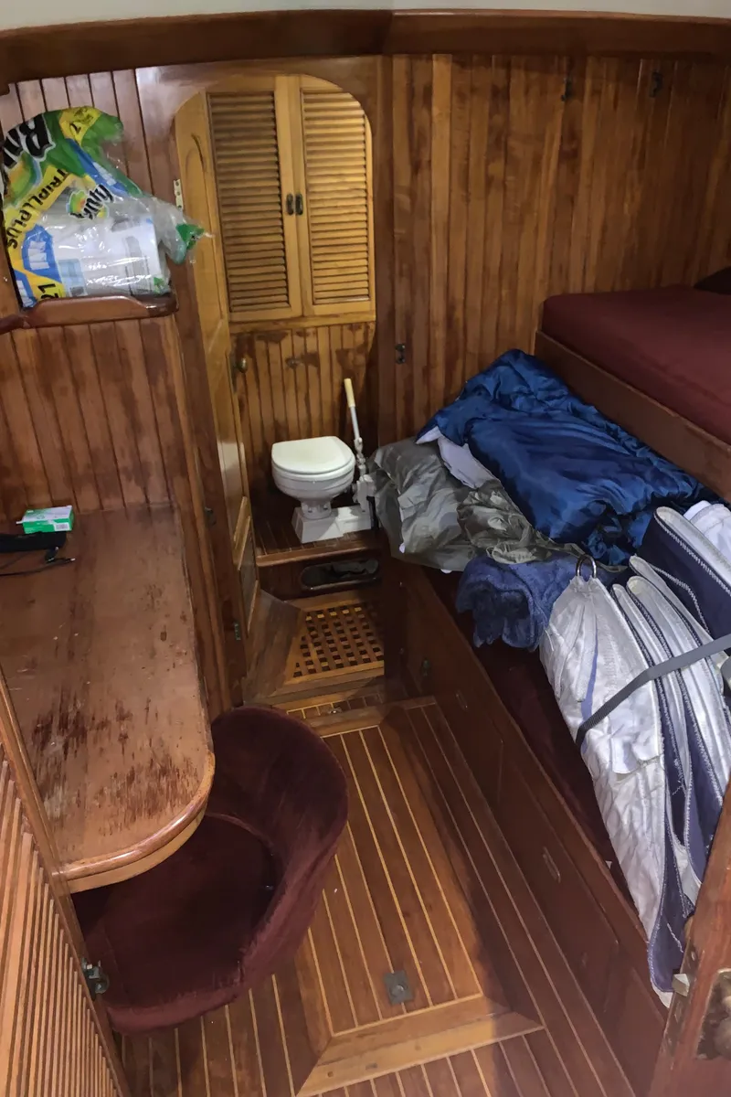 Slide: The Image of 1983 Liberty Center Cockpit interior with wooden paneling, desk, chair, and compact toilet area. - 27