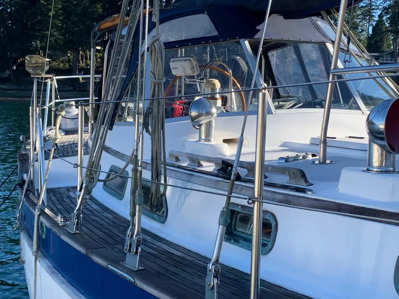 Slide: The Image of 1983 Liberty Center Cockpit sailboat with polished deck and railing, docked in a serene marina. - 3
