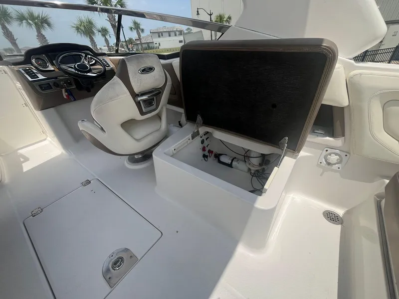 Slide: The Image of 2013 Chaparral 257 SSX boat interior with open storage compartment and steering wheel. - 30