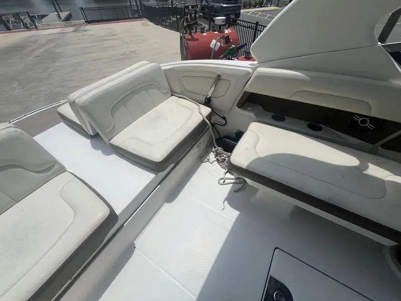 Slide: The Image of 2013 Chaparral 257 SSX boat interior with white seating and storage compartments. - 32
