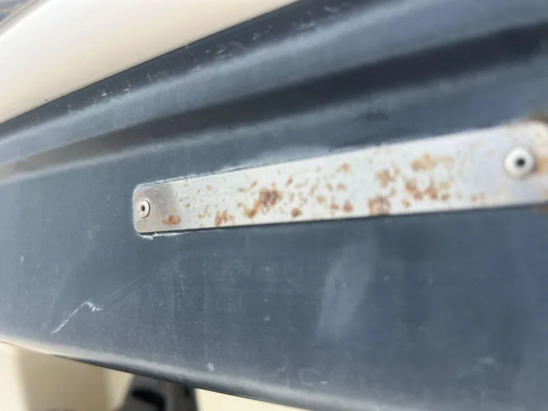 Slide: The Image of Close-up of a rusted metal plate on a 2013 Chaparral 257 SSX boat. - 38