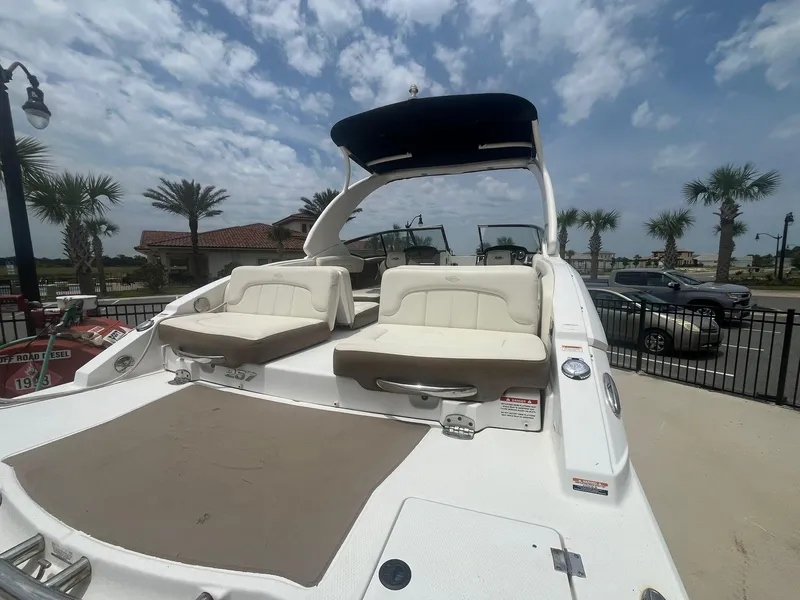 Slide: The Image of 2013 Chaparral 257 SSX boat with spacious seating, docked under a partly cloudy sky. - 39
