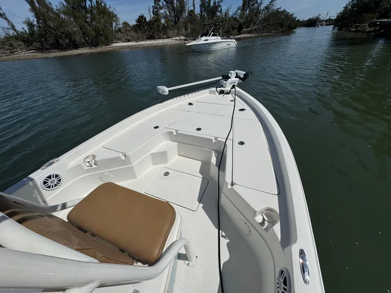 Slide: The Image of 2022 Skeeter SX230 boat on calm water, featuring spacious deck and seating. - 29