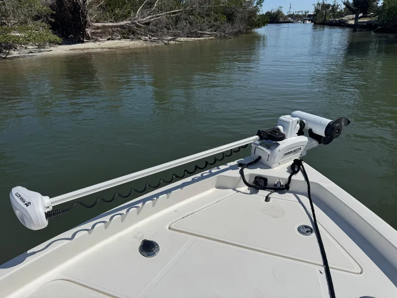 Slide: The Image of 2022 Skeeter SX230 boat with trolling motor on calm waterway. - 31