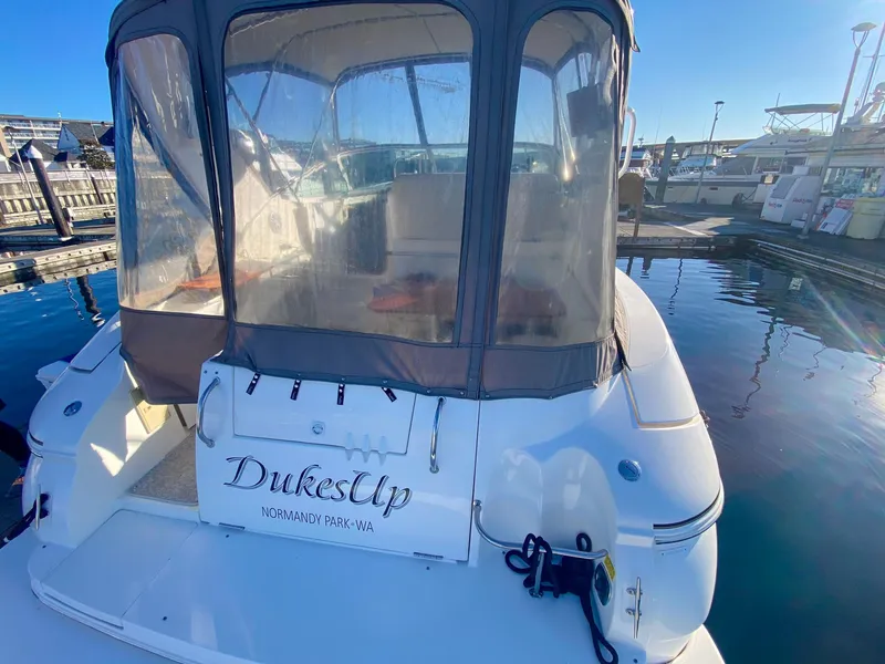 Slide: The Image of 2003 Cruisers Yachts 3275 Express docked, featuring covered seating area and "DukesUp" name. - 10