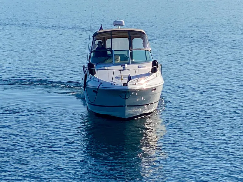 Slide: The Image of 2003 Cruisers Yachts 3275 Express on calm blue water, front view. - 2