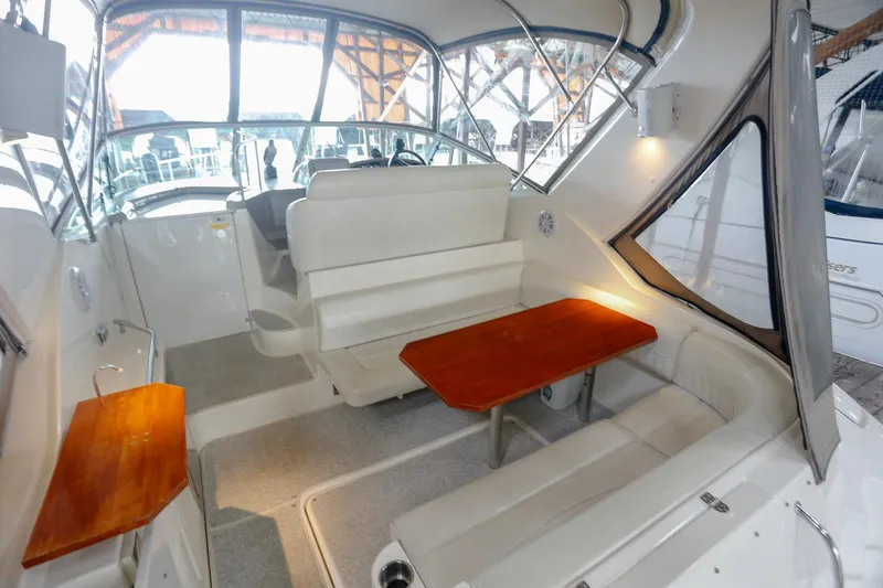 Slide: The Image of 2003 Cruisers Yachts 3275 Express interior with seating and wooden tables. - 21