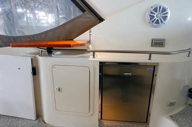 Slide: The Image of 2003 Cruisers Yachts 3275 Express interior with storage, fridge, and speaker. - 24