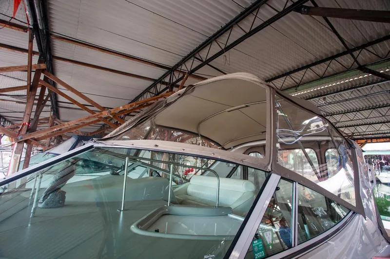Slide: The Image of 2003 Cruisers Yachts 3275 Express boat under a covered dock, showcasing cockpit and canopy. - 34