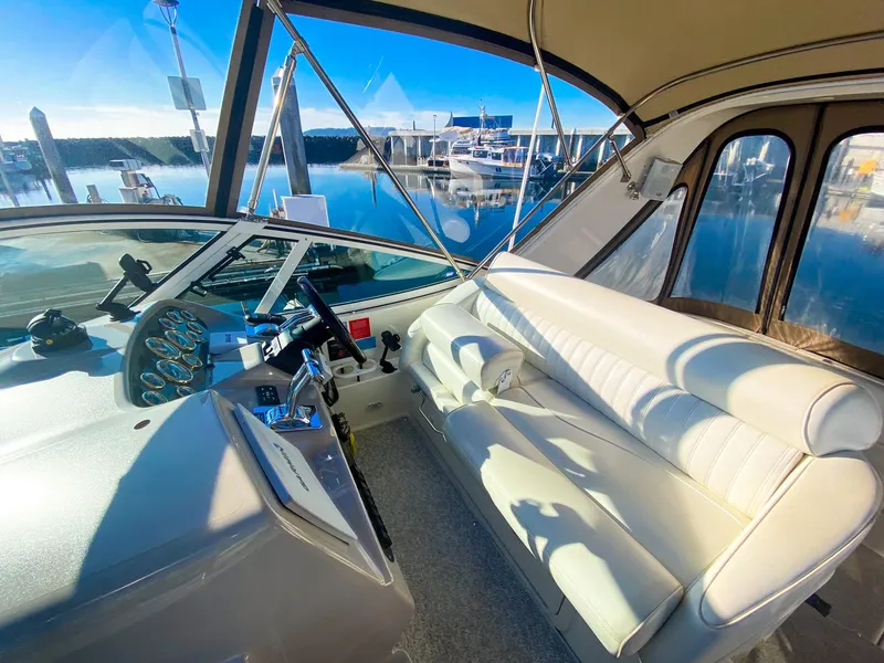 Slide: The Image of 2003 Cruisers Yachts 3275 Express cockpit with white seating and marina view. - 17
