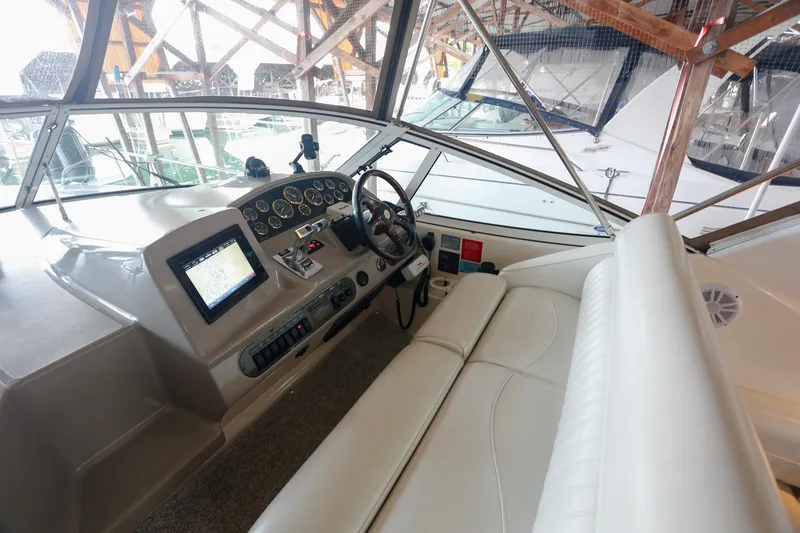 Slide: The Image of 2003 Cruisers Yachts 3275 Express cockpit with steering wheel, navigation system, and comfortable seating. - 22