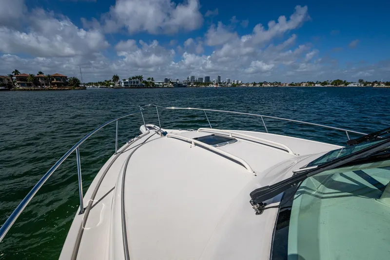 Slide: The Image of 2014 Pursuit 345os boat cruising on a sunny day with city skyline in background. - 16