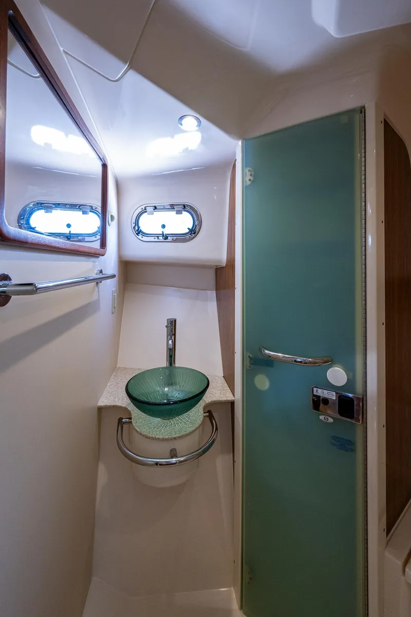 Slide: The Image of 2014 Pursuit 345os boat bathroom with glass sink and modern fixtures. - 30