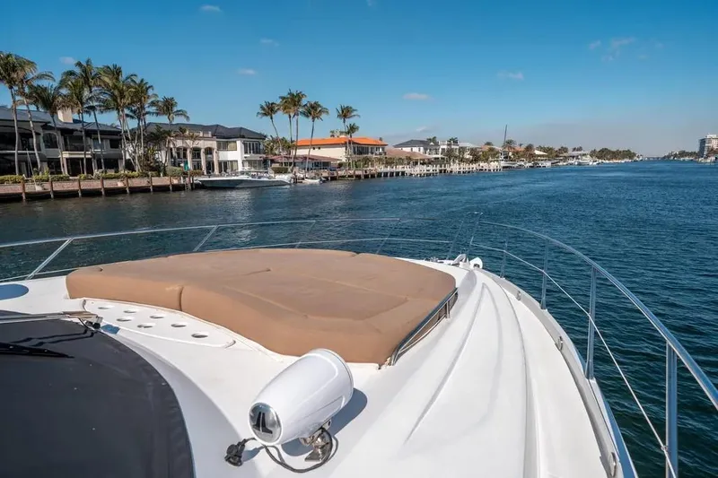 Slide: The Image of 2006 Sunseeker 64 Manhattan yacht cruising along a scenic waterfront with palm trees. - 26