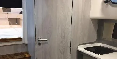 Slide: The Image of Interior of 2025 Hanover 387 Outboard Classic Luxury Edition boat, featuring modern kitchenette. - 11